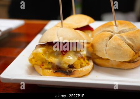 Typischer Mini-Burger-Snack aus dem Baskenland, Pinchos oder Pinxtos, kleines Stück Brot mit verschiedenen Belägen, serviert in der Bar in San-Sebastian oder Bilba Stockfoto