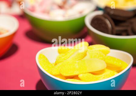Gelben Gelees, Cookies und andere Süßwaren in hellen Schalen.  Lustige bunte Nahaufnahme von verschiedenen Arten von Süßigkeiten. Leckere Snacks Proben im Candy shop Stockfoto