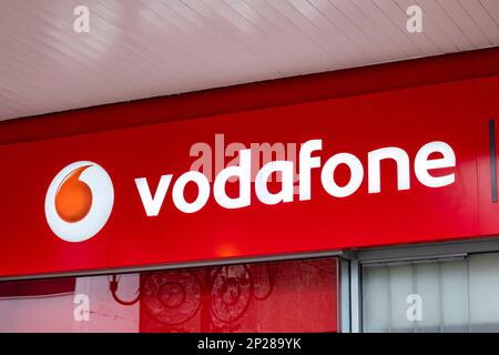 Nahaufnahme des Vodafone-Mobilfunknetzschilds an der Außenwand von Großbritannien Stockfoto