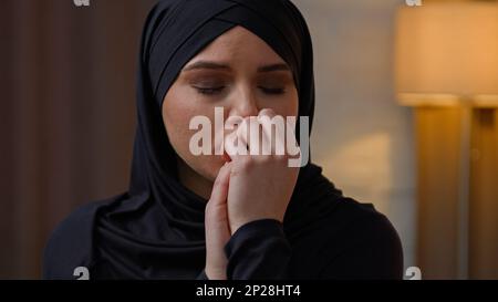 Traurig enttäuscht, verärgert, weinend arabische muslimische araberin Frau, multirassische Frau, Frau, sitzt in der Wohnung, ängstliche Freundin, weint allein, macht sich Sorgen Stockfoto