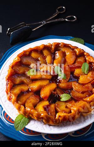 Speisekonzept hausgemachte Tarte Tatin Upside-down-Apfelkuchen auf schwarzem Schieferstein mit Kopierbereich Stockfoto