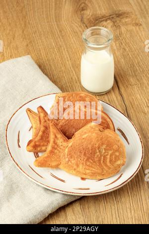 Japanisches Taiyaki, Fischförmiger Kuchen mit süßroter Bohnenpaste, ähnlich wie koreanischer Bungeoppang. Auf Einem Holztisch Stockfoto