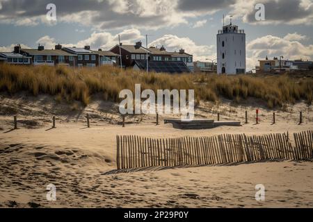 Weißer Leuchtturm im Badeort Katwijk aan Zee vom Sandstrand aus gesehen Stockfoto