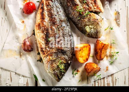 Leckere geröstete Meerbrasse mit Kartoffeln, Kirschtomaten und Thymian Stockfoto