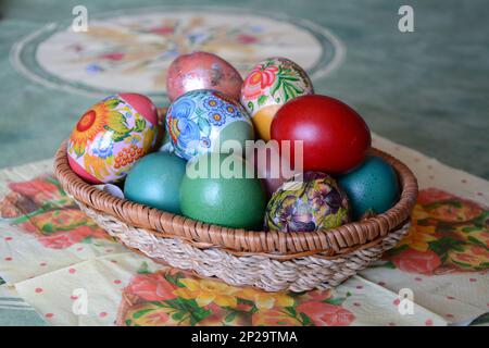 Nahaufnahme eines Webkorbs mit bunten gefärbten Eiern für die traditionelle Osterfeier in Bulgarien im april. Horizontales Bild mit selektivem FO Stockfoto