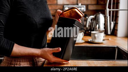 Ein Mädchen öffnet in der Küche einen Tee-Metallbehälter Stockfoto