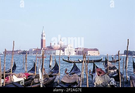 Die Insel San Giorgio Maggiore ist von der Hauptinsel über das Wasser zu sehen. Im Vordergrund befinden sich Gondeln. Venedig, Italien, 1967 Stockfoto