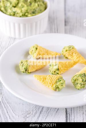 Tortilla-Chips, gefüllt mit Guacamole auf dem Teller Stockfoto