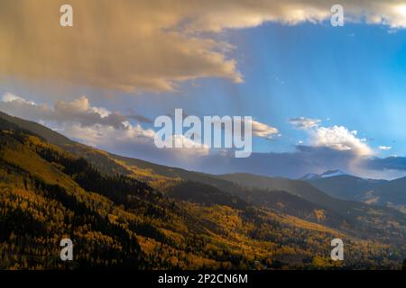 Blick auf die Herbstblätter auf der Bergseite mit dem Berg des Heiligen Kreuzes im Hintergrund Stockfoto