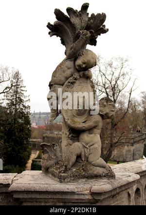 Putti-Skulptur mit einem Monogramm in den Hofgärten der Residenz, Barockpalast Prinz-Bischöfe, Würzburg, Deutschland Stockfoto