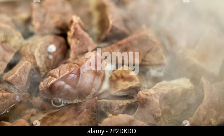 Schweinelunge in abgekochtem heißem Wasser. Nahaufnahme der Zubereitung eines thailändischen Gerichts. Gekochte Rind- oder Rinderlunge, Eingeweide aus Schweinefleisch. Stockfoto