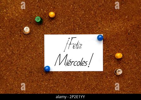 Weiße und farbige Notizen auf Korktafel mit Nachricht auf spanisch „Happy Wednesday“ Stockfoto