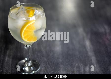 Orange Gin auf altem grauen Tisch mit roten Kugeln Stockfoto