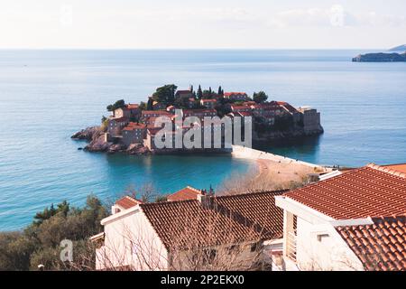 Blick auf Sveti Stefan, eine Stadt in der Gemeinde Budva, Budva Riviera, an der Adriaküste, St. Stephen Island, Montenegro, sonniger Tag mit blauer Stange Stockfoto