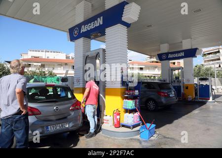 Aegean Tankstelle Mann betankt Auto an den Pumpen auf der Straße zum internationalen Flughafen Athen Griechenland Stockfoto