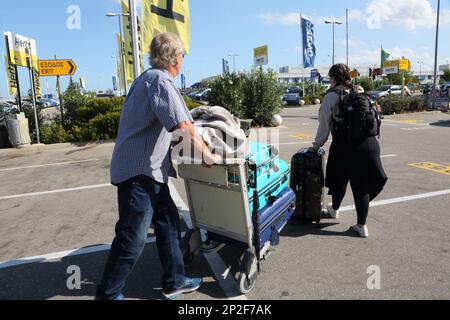 Athen Griechenland Touristen mit Gepäck im Flughafen Trolley bei Autovermietungen vom Internationalen Flughafen Athen (AIA) Eleftherios Venizelos Stockfoto