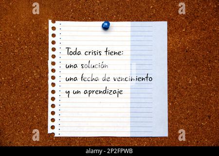 Weißer Hinweis auf Korktafel mit Botschaft in spanischer Sprache „jede Krise hat eine Lösung, ein Ablaufdatum und eine Lernphase“ Stockfoto