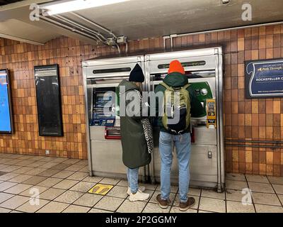 Ein Paar an einem U-Bahn-Metrokartenautomaten an einem Bahnhof in Manhattan, New York City. Stockfoto