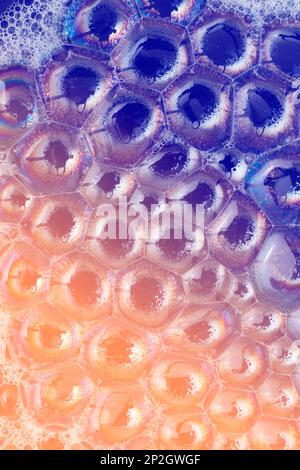 Nahaufnahme, Makroaufnahme einer Seifenblase, mehrfarbiger Regenbogen mit gelben, violetten, rosa, blauen und grünen Farben auf schwarzem Hintergrund. Stockfoto
