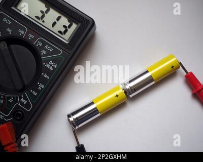 Spannungsmessung am Voltmeter von zwei seriell verbundenen Alkali-Mangan-Batterien. AA-Zellen. Stockfoto