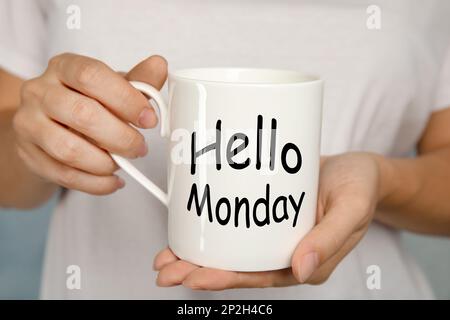 Beginnen Sie Ihre Woche mit guter Laune. Frau mit Keramikbecher und Text Hellow Monday, Nahaufnahme Stockfoto