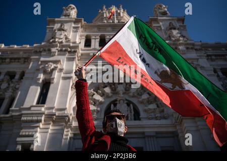 Madrid, Spanien. 04. März 2023. Eine Frau schwenkt eine iranische Flagge mit der Botschaft Frau, Leben und Freiheit während der Demonstration. Iranische Staatsbürger mit Wohnsitz in Spanien protestieren auf der Plaza de Cibeles, Madrid, gegen die Hunderte von Fällen von Mädchen, die in Schulen vergiftet wurden, die seit November letzten Jahres im Iran gemeldet wurden. Kredit: SOPA Images Limited/Alamy Live News Stockfoto