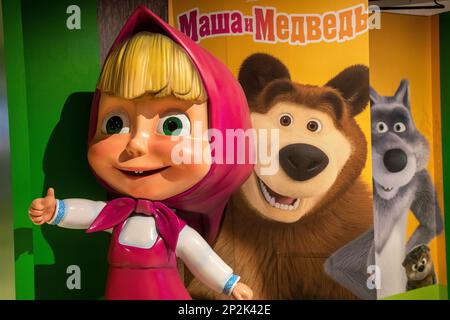 Moskau, Russland. 4. März 2023. Eine Figur von Mascha und ein Banner, das die Helden des beliebten russischen Kinderkomitees „Mascha und der Bär“ in einem Inneren des Central Children's Store in Moskau, Russland, darstellt Stockfoto