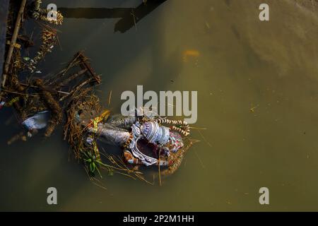 Überreste von entsorgten Bildern der Göttin Kali, die am Flussufer des Hooghly in Kalkutta, der Hauptstadt von Westbengalen, Indien, schwebt Stockfoto