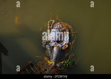 Überreste von entsorgten Bildern der Göttin Kali, die am Flussufer des Hooghly in Kalkutta, der Hauptstadt von Westbengalen, Indien, schwebt Stockfoto