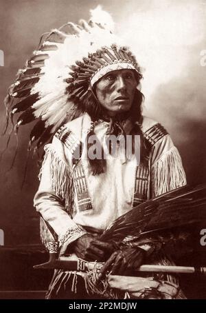 Studioporträt von Sioux Chief High Horse (1852-1931) im Jahr 1900 mit einem goldenen Adlerflügelventilator und einem mit schwarzem Stein versehenen Bleirohr. (Foto: John A. Anderson) Stockfoto