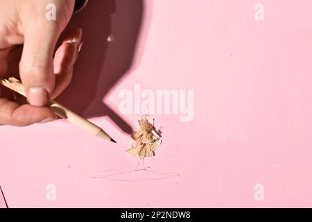 Eine Frau mit Handschwanz, ein rosafarbener Bleistift-Makroschuss. Stockfoto