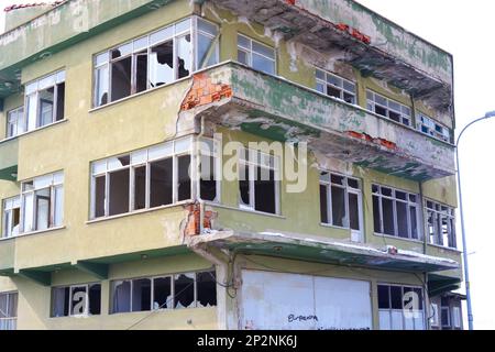 Altes Wohngebäude mit kaputten Fenstern und beschädigten Wänden tagsüber in der Stadt Stockfoto