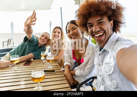 Glückliche Gruppe von verschiedenen jungen Freunden, die Selfie-Porträt an der Strandbar machen Stockfoto