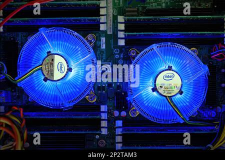 Saint John, NB, Kanada - 2. Oktober 2014: Leuchtende Intel-Fans auf CPUs in einem Dual-Prozessor-Computer. Die Lüfter drehen sich, das Motherboard ist ziemlich dunkel. Stockfoto