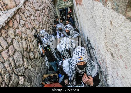 Nablus, Palästina. 04. März 2023. Maskierte palästinensische Schützen des Balata-Bataillons halten ihre Waffen während einer Gedenkfeier an zwei Palästinenser, die vor einem Monat von der israelischen Armee erschossen wurden, im Flüchtlingslager Balata östlich von Nablus im Westjordanland. Viele palästinensische Gruppierungen und militante Kräfte zeigen ihre Waffen und ihre Stärke während der gesamten Gedenkfeier für die Palästinenser, die von der israelischen Armee getötet werden, um der israelischen Armee das Ausmaß ihrer Stärke zu zeigen. Kredit: SOPA Images Limited/Alamy Live News Stockfoto