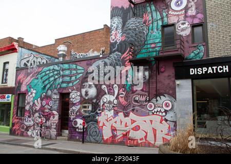 Kreatives Graffiti Street Art Wandgemälde, das ein Gebäude in einer Seitenstraße von Montreal, Quebec, Kanada säumt Stockfoto