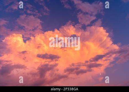 Purpurfarbener Himmel in der Dämmerung am Abend, dunkler Hintergrund am Himmel. Farbenfroher Himmel. Abendhintergrund. Dramatischer Sonnenaufgang, Sonnenuntergang, rosa violett blauer Himmel mit Cirru Stockfoto