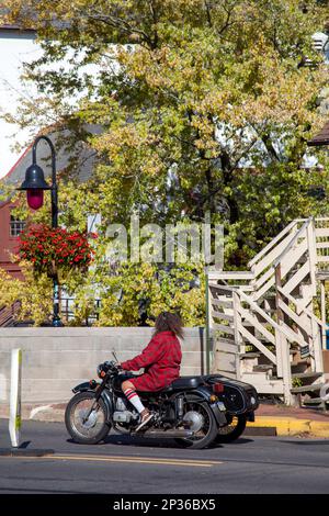 Frau auf Old Motorcycle auf der Main Road durch New Hope Pennsylvania, USA Stockfoto