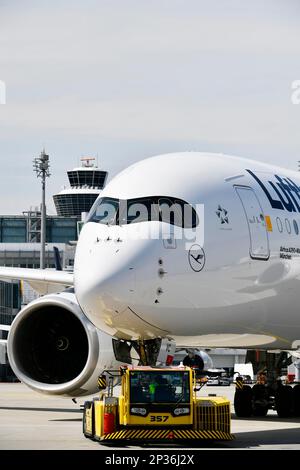 Lufthansa Airbus A350-900 Abschleppen mit Rückstoßwagen vor Terminal 2 mit Turm, Flughafen München, Oberbayern, Bayern, Deutschland Stockfoto