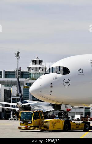 Lufthansa Airbus A350-900 Abschleppen mit Rückstoßwagen vor Terminal 2 mit Turm, Flughafen München, Oberbayern, Bayern, Deutschland Stockfoto