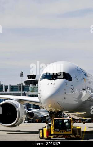 Lufthansa Airbus A350-900 Abschleppen mit Rückstoßwagen vor Terminal 2 mit Turm, Flughafen München, Oberbayern, Bayern, Deutschland Stockfoto