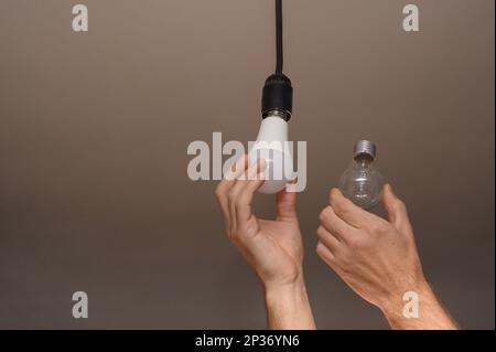 Mann, der die Glühlampe in der Lampe wechselt, Nahaufnahme Stockfoto