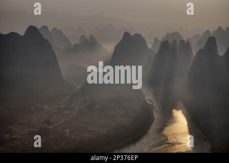 Blick auf Kalksteinfelsen am Fluss bei Sonnenaufgang, Li-Fluss, Guilin, Guangxi Zhuang Autonome Region, China Stockfoto