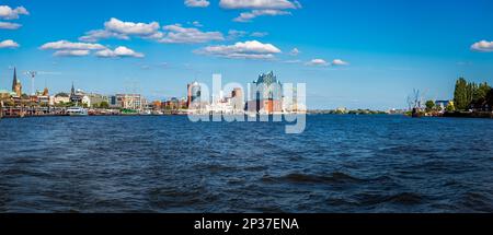 Panoramablick auf den Hamburger Hafen mit seiner maritimen Industrie und den majestätischen Gebäuden am Wasser, von der elbe aus gesehen. Stockfoto