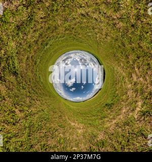 Blaues Loch Kugel kleiner Planet in grünem Gras runder Rahmenhintergrund. Stockfoto