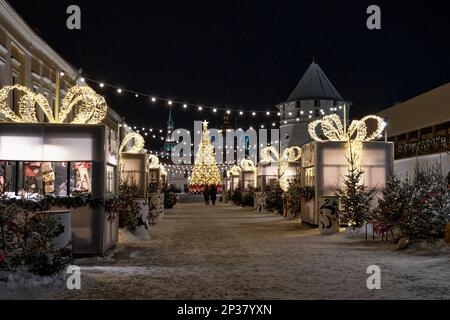 Kasan, Russland - 11. Januar 2023: Neujahrsmesse im Kasan-Kreml. Im Innenhof der Büros am Abend. Festliche Beleuchtung. Schneller Foo Stockfoto