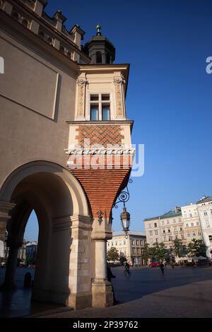 Das Erkerfenster ragt aus der Ecke der Renaissance Tuchhalle (Sukiennice) in Krakau, Polen. Stockfoto