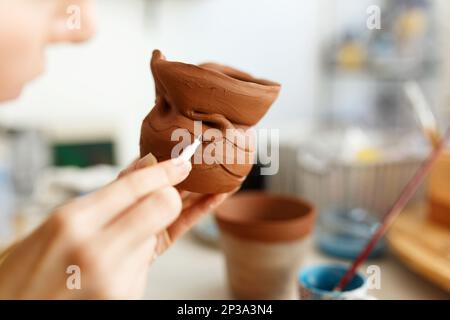 Weibliche Hände halten eine Schüssel zum Gießen von Tonprodukten. Formmethode zur Herstellung von Tonschalen. Handarbeit. Töpferei. Stockfoto