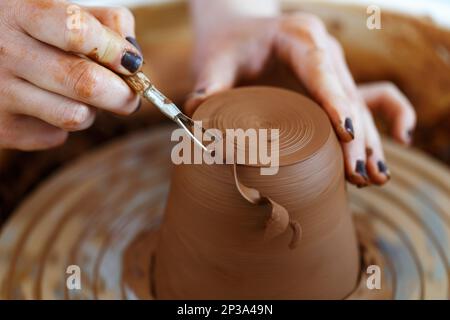 Weibliche Hände halten eine Schüssel zum Gießen von Tonprodukten. Formmethode zur Herstellung von Tonschalen. Handarbeit. Töpferei. Nahaufnahme Stockfoto