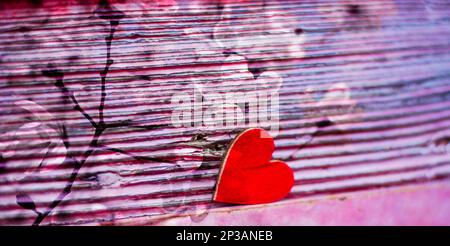 Ein Herz und Blumen auf pinkfarbenem Hintergrund für Frauen Stockfoto